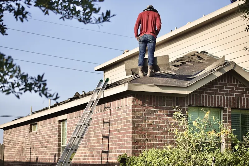 Professional roofer working on a residential roof in Nottingham Manor